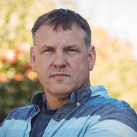 portrait of farmer standing in apple orchard on a sunny day